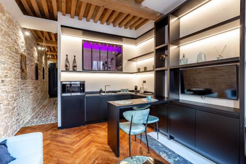 une cuisine avec des placards noirs et un bar avec un évier dans l'établissement SWEET LEONE JACUZZI PLACE TERREAUX, à Lyon