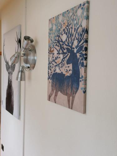 a painting of a deer on a wall next to a lamp at das Loft in Bad Kleinkirchheim