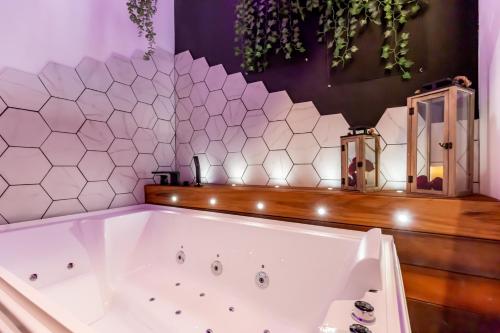 La salle de bains est pourvue d'une baignoire blanche. dans l'établissement SWEET LEONE JACUZZI PLACE TERREAUX, à Lyon