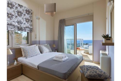 a bedroom with a bed with a view of the ocean at Elkysti Crete in Kalamaki