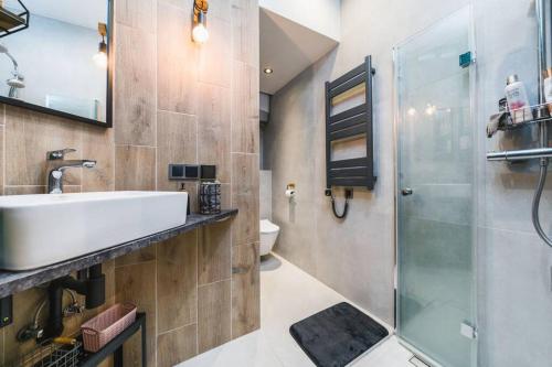 y baño con lavabo y ducha. en Zender Kazimierz Apartment, en Cracovia