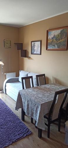 a bedroom with a table and chairs and a bed at Apartamenty Kraków -Podgorze M&W in Krakow
