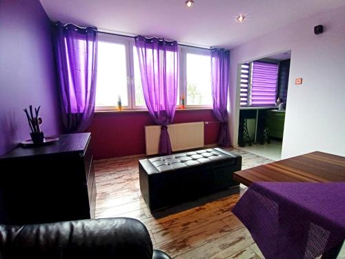 a living room with purple curtains and a couch at Nastrojowe Mieszkanie Plac Krakowski Gliwice 60m2 in Gliwice