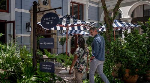 a man and a woman standing under an umbrella at Labotessa Luxury Boutique Hotel in Cape Town