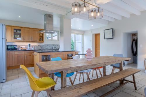 une cuisine et une salle à manger avec une table et des chaises en bois dans l'établissement La Riolle Zoo de Beauval -Châteaux de la Loire, à Chémery
