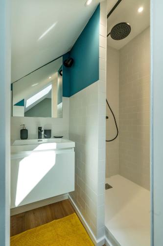 une salle de bain avec un lavabo et une douche dans l'établissement Maloca' Joffre, à La Roche-sur-Yon