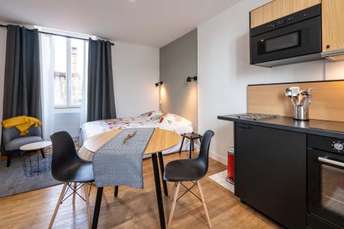 une petite cuisine avec une table et des chaises dans une pièce dans l'établissement Maloca' Joffre, à La Roche-sur-Yon