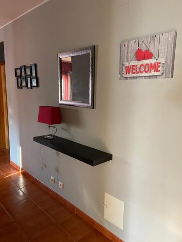 a wall with a welcome sign and a mirror at Gomeira Terrace in Cabanas de Tavira