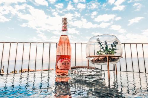 a bottle of beer sitting on a table next to a pool at YalaRent Migdalor Apartments with Sea Views Tiberias in Tiberias