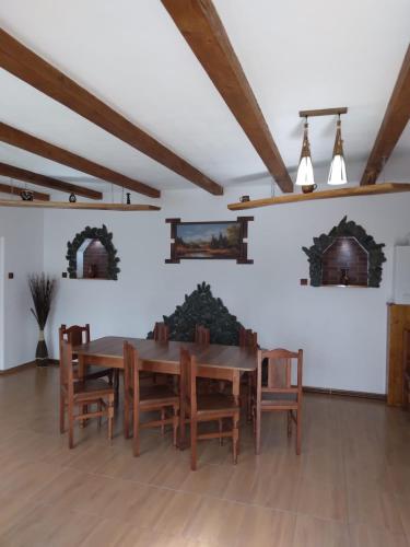 a dining room with a wooden table and chairs at Pensiunea Bujor de Munte in Cîrţişoara