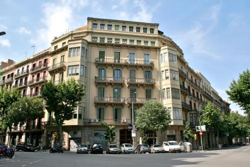 a large building with cars parked in front of it at Hostal Eixample in Barcelona