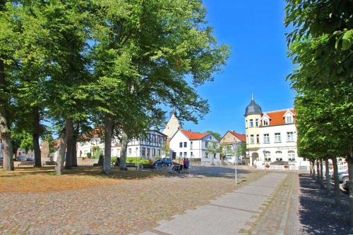 ヴェセンベルクにあるFerienhaus Wesenberg SEE 5461の白い建物と木々の町の通り