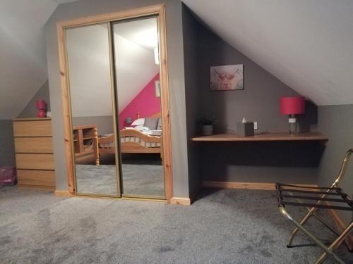 a room with a mirror and a bed in a attic at Corrie View in Invergarry