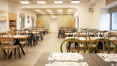 a classroom with tables and chairs in a room at איילת השחר אירוח גלילי - Ayelet Hotel in Ayelet HaShahar