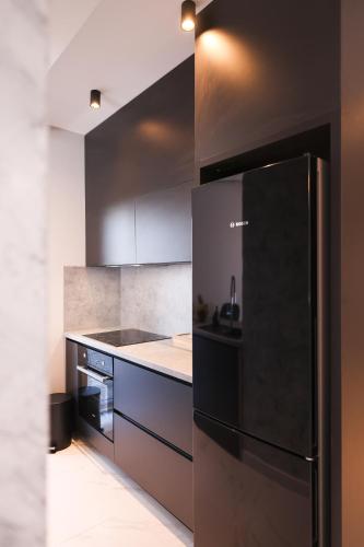 a kitchen with a black refrigerator and a stove at D-Palace Apartments-Olive tree in Donji Zemunik
