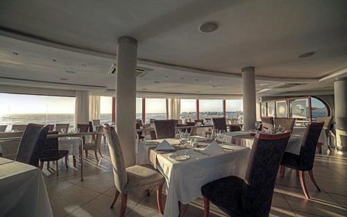 a restaurant on a ship with tables and chairs at Beach Lodge in Swakopmund