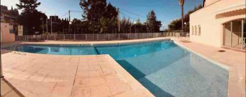 een groot zwembad met blauw water bij appartement superbe Vue Mer,piscine,parking privee, in La Croix-Valmer