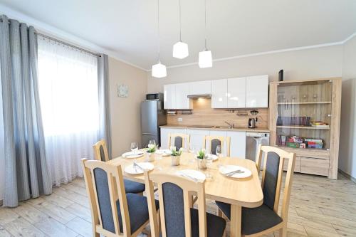 a kitchen and dining room with a wooden table and chairs at Apartamenty EverySky - Dom Źródlana 11 in Kowary