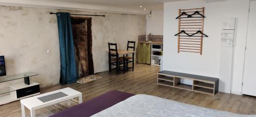 a living room with a bed and a table and chairs at Studio Les Cadichons de la Grange in Saint-Péray