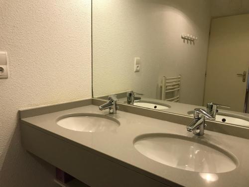 a bathroom with two sinks and a large mirror at Grand T3 centre Cauterets 6 à 8 pers. WIFI. Balcon in Cauterets