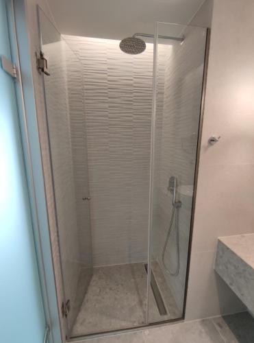 a shower with a glass door in a bathroom at Onar in Sarti in Sarti