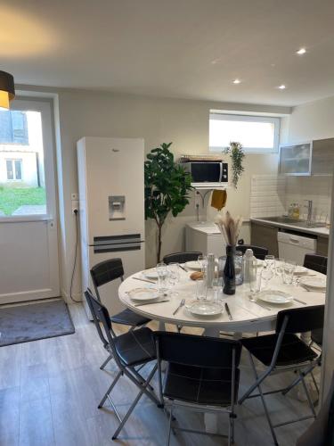 une cuisine avec une table et des chaises dans une cuisine dans l'établissement Arromanches D-Day Cottage, à Arromanches-les-Bains