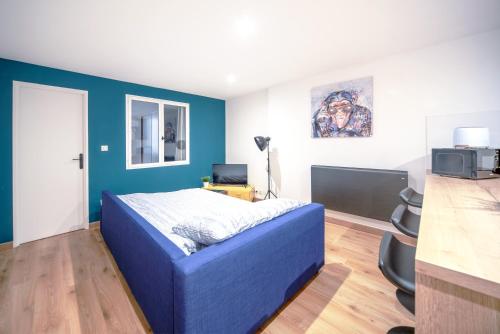 um quarto com uma cama azul e uma parede azul em Appartement POP au coeur du centre ville em Mâcon