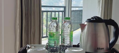 duas garrafas de água numa mesa ao lado de uma cafeteira em Jaye's Homestay em Kandy