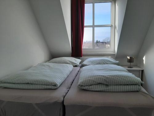 1 dormitorio con 2 camas y ventana en Ferienwohnung Schloßstr. 8, Mirow, en Mirow