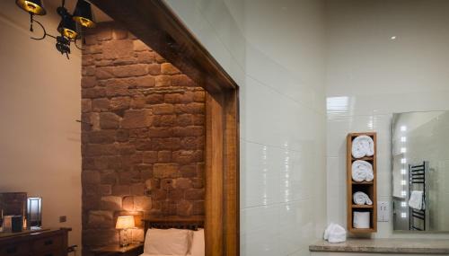 a room with a brick wall with clocks on the wall at Heaton House Farm in Macclesfield