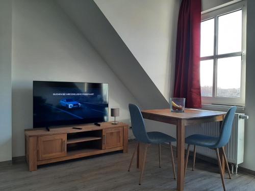 sala de estar con TV y mesa con sillas en Ferienwohnung Schloßstr. 8, Mirow, en Mirow