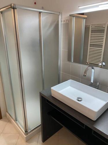 a bathroom with a white sink and a shower at Appartamento Oliva mit Seeblick in Toscolano Maderno
