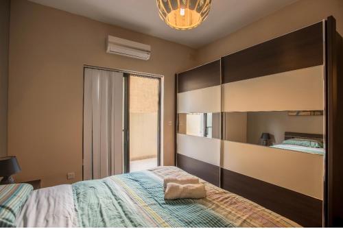 a bedroom with a large bed and a large mirror at Bugibba Square Seaview 3 Bedroom Apartment in St. Paul's Bay