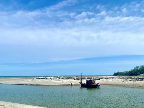 a boat sitting in the water on the beach at Sand-D House Pool villa B30 at Rock Garden Beach Resort Rayong in Mae Pim