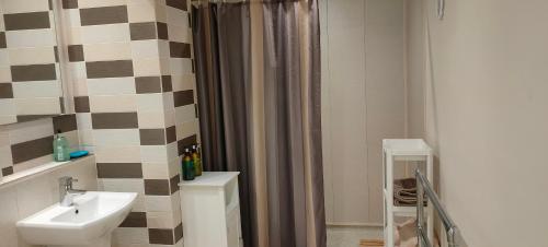 a bathroom with a sink and a shower curtain at Fishtail House - Stylish Apartments minutes from the sea in Hornsea