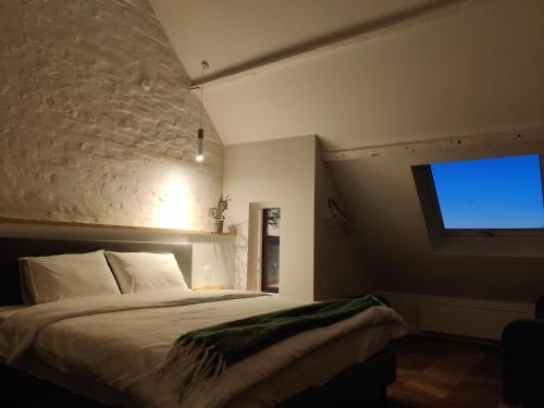 a bedroom with a bed and a flat screen tv at Zennon in Geraardsbergen