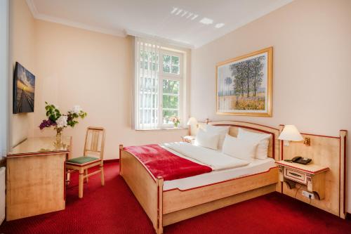 a bedroom with a large bed and a window at Vineta Strandhotels in Zinnowitz