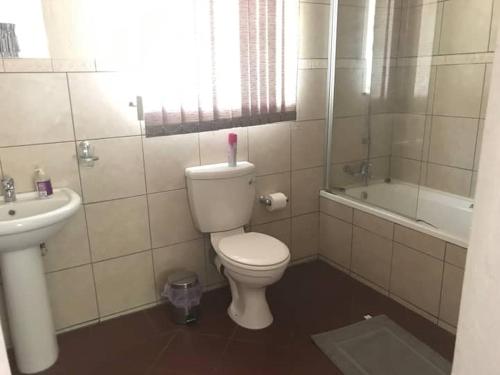 een badkamer met een toilet en een wastafel bij Private and cozy in Sandton