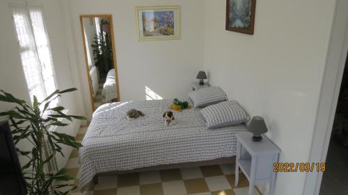 a bedroom with a bed with two dogs on it at le tilleul in Sainte-Geneviève-lès-Gasny