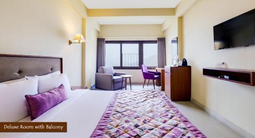 a hotel room with a bed and a table and chairs at Mount Himalayan Hotel in Gangtok