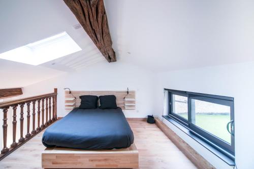 ein Schlafzimmer mit einem Bett und einem großen Fenster in der Unterkunft Loft au coeur du centre ville in Mâcon