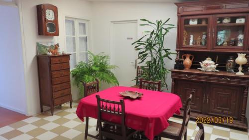 une salle à manger avec une table avec une nappe rouge dans l'établissement le tilleul, à Sainte-Geneviève-lès-Gasny