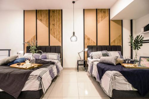 a bedroom with two beds and a table between them at 3 Towers Klcc By Tenang Homes in Kuala Lumpur