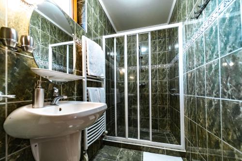 a bathroom with a sink and a glass shower at Estike Apartman in Gyula