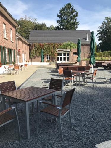 a group of tables and chairs with umbrellas at Die LÜ - Lüttelforster Mühle in Schwalmtal