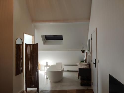 a white bathroom with a tub and a sink at Fáilte Muur in Geraardsbergen