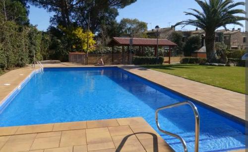 a swimming pool with blue water in a yard at Apt con piscina en Calella de Palafrugell, parking gratuito in Calella de Palafrugell