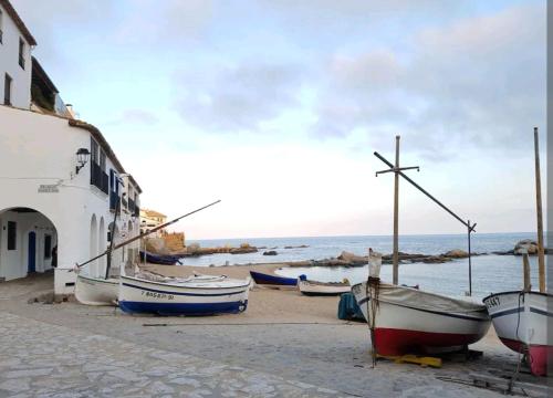 a group of boats sitting on the sand near the water at Apt con piscina en Calella de Palafrugell, parking gratuito in Calella de Palafrugell
