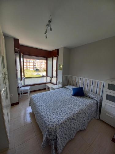 een slaapkamer met een bed met een blauw kussen erop bij Apartamento Noja Beach in Noja