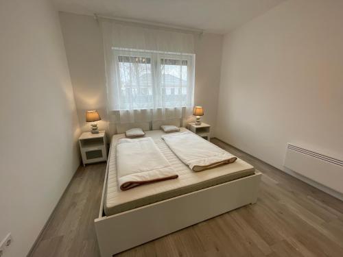 a bedroom with a bed and two night stands at Sorrento Deluxe Apartment - Jacuzzi in Siófok